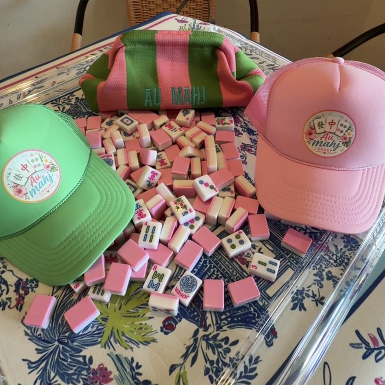 Au Mahj Group pink mahjong tile set with branded pouch and trucker hats